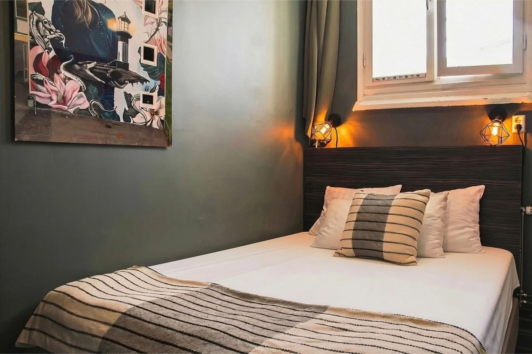 Hotellrum med säng och konstverk